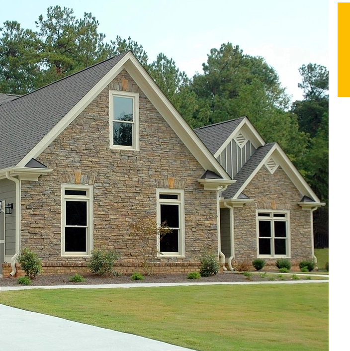 A house with two windows and a lawn.