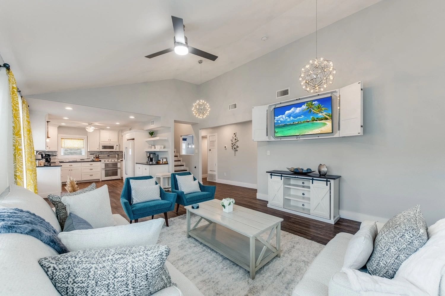 A living room with two blue chairs and a white couch